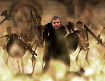 Screenshot from Diablo 2 opening cinematic, with the Wanderer, leaning on his cane, surrounded by fire and skeleton monsters. Mark's face is on the Wanderer.